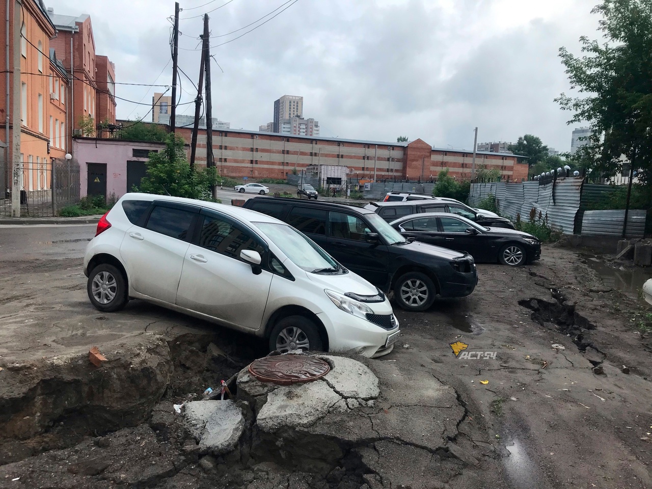 В Новосибирске после дождя на парковке стали проваливаться машины